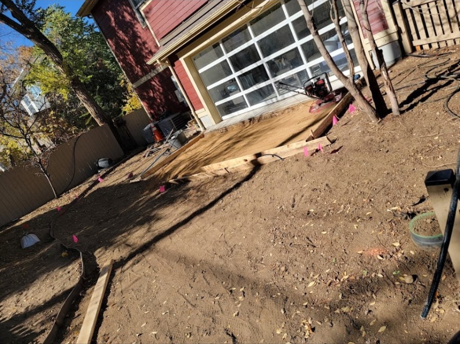 Patio base — Aggregate spread, levelled and plate-compacted for the new patio.