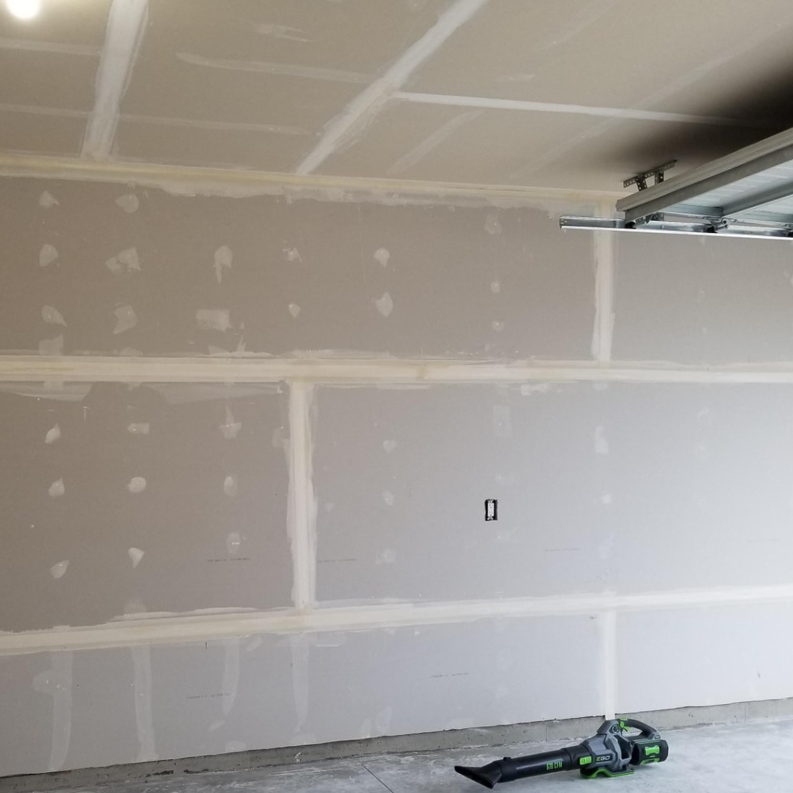 Taping & mudding — Taped joints and mudded screw heads on walls and ceiling, ready for skim and sand.